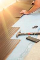 Man Installing New Laminate Wood Flooring photo