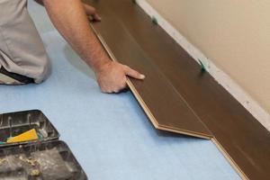 Man Installing New Laminate Wood Flooring photo