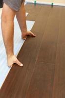 Man Installing New Laminate Wood Flooring photo