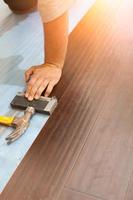 Man Installing New Laminate Wood Flooring photo