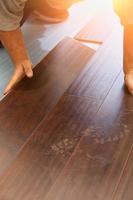 Man Installing New Laminate Wood Flooring photo