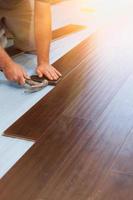 Man Installing New Laminate Wood Flooring photo