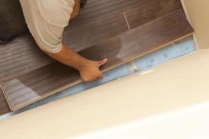 Man Installing New Laminate Wood Flooring photo