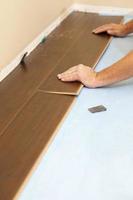 Man Installing New Laminate Wood Flooring photo