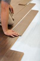 Man Installing New Laminate Wood Flooring photo