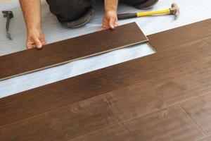 Man Installing New Laminate Wood Flooring photo