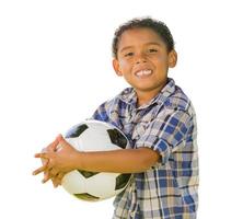 niño de raza mixta sosteniendo un balón de fútbol en blanco foto