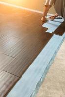 Man Installing New Laminate Wood Flooring photo