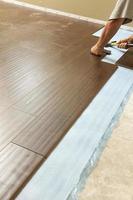 Man Installing New Laminate Wood Flooring photo