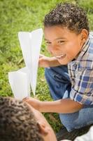 Mixed Race Father and Son Playing with Paper Airplanes photo