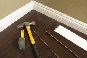 Hammer, Laminate Flooring and New Baseboard Molding photo