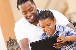 Mixed Race Father and Son Using Touch Pad Computer Tablet photo