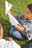 Mixed Race Father and Son Playing with Paper Airplanes photo