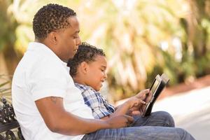 Mixed Race Father and Son Using Touch Pad Computer Tablet photo