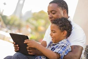Mixed Race Father and Son Using Touch Pad Computer Tablet photo