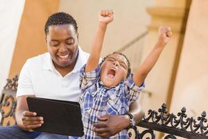 Mixed Race Father and Son Using Touch Pad Computer Tablet photo