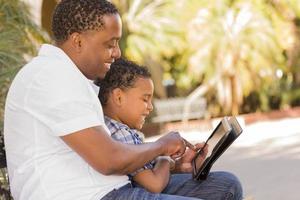 Mixed Race Father and Son Using Touch Pad Computer Tablet photo