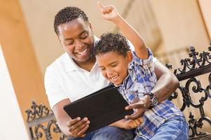 Mixed Race Father and Son Using Touch Pad Computer Tablet photo