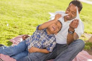 Mixed Race Father and Son Playing with Paper Airplanes photo