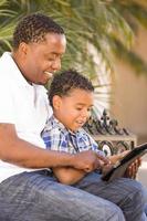 Mixed Race Father and Son Using Touch Pad Computer Tablet photo
