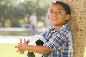 Mixed Race Boy Holding Soccer Ball in the Park photo