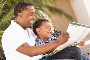 Mixed Race Father and Son Reading Park Brochure Outside photo