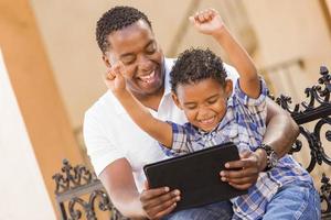 Mixed Race Father and Son Using Touch Pad Computer Tablet photo