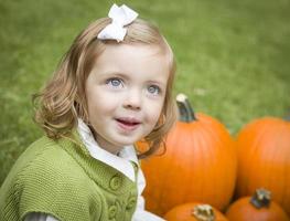 Cute Young Child Girl Enjoying the Pumpkin Patch. photo