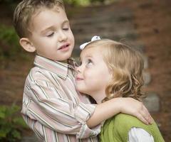 Adorable Brother and Sister Children Hugging Outside photo