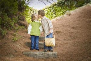dos niños con canasta besándose afuera en escalones foto