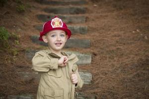 Adorable Child Boy with Fireman Hat Playing Outside photo