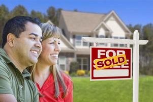 Couple in Front of Sold Real Estate Sign and House photo