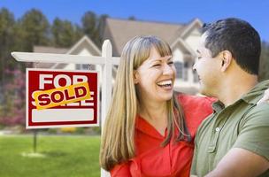 Couple in Front of Sold Real Estate Sign and House photo