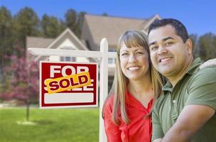 Couple in Front of Sold Real Estate Sign and House photo