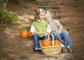 Brother and Sister Children on Wood Steps with Pumpkins Whispering photo