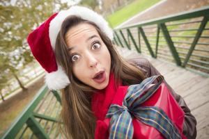 Pretty Woman Wearing a Santa Hat with Wrapped Gift photo