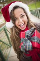 Pretty Woman vistiendo un gorro de Papá Noel con regalo envuelto foto