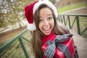 Pretty Woman Wearing a Santa Hat with Wrapped Gift photo