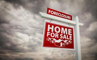 Red Foreclosure Home For Sale Real Estate Sign Over Cloudy Sky photo