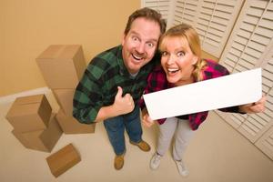 Goofy Goofy Thumbs Up Couple Holding Blank Sign Surrounded by Boxes photo