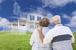 Senior Couple Faces Ghosted House Drawing, Green Grass Hill Behind photo