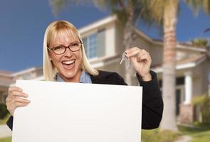 Excited Woman Holding House Keys and Blank Real Estate Sign photo