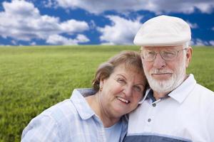 Loving Senior Couple Standing in Grass Field photo