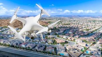 Unmanned Aircraft System Quadcopter Drone In The Air Over Residential Neighborhood. photo