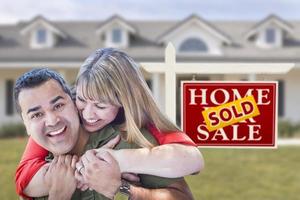 Mixed Race Couple in Front of Sold Real Estate Sign and House photo
