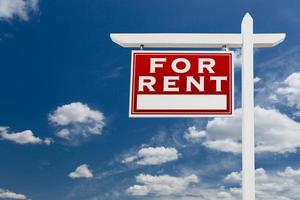 Left Facing For Rent Real Estate Sign Over Blue Sky and Clouds With Room For Your Text. photo