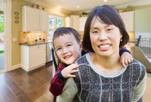 Chinese Mother and Mixed Race Child Inside Beautiful Kitchen. photo