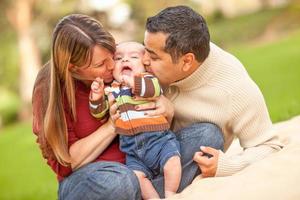 feliz familia de raza mixta haciendo un picnic y jugando en el parque. foto