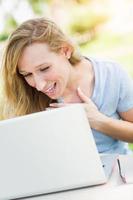 Young Adult Woman Live Video Chatting Outdoors Using Her Laptop. photo