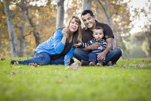 Happy Mixed Race Ethnic Family Playing with Bubbles In The Park photo